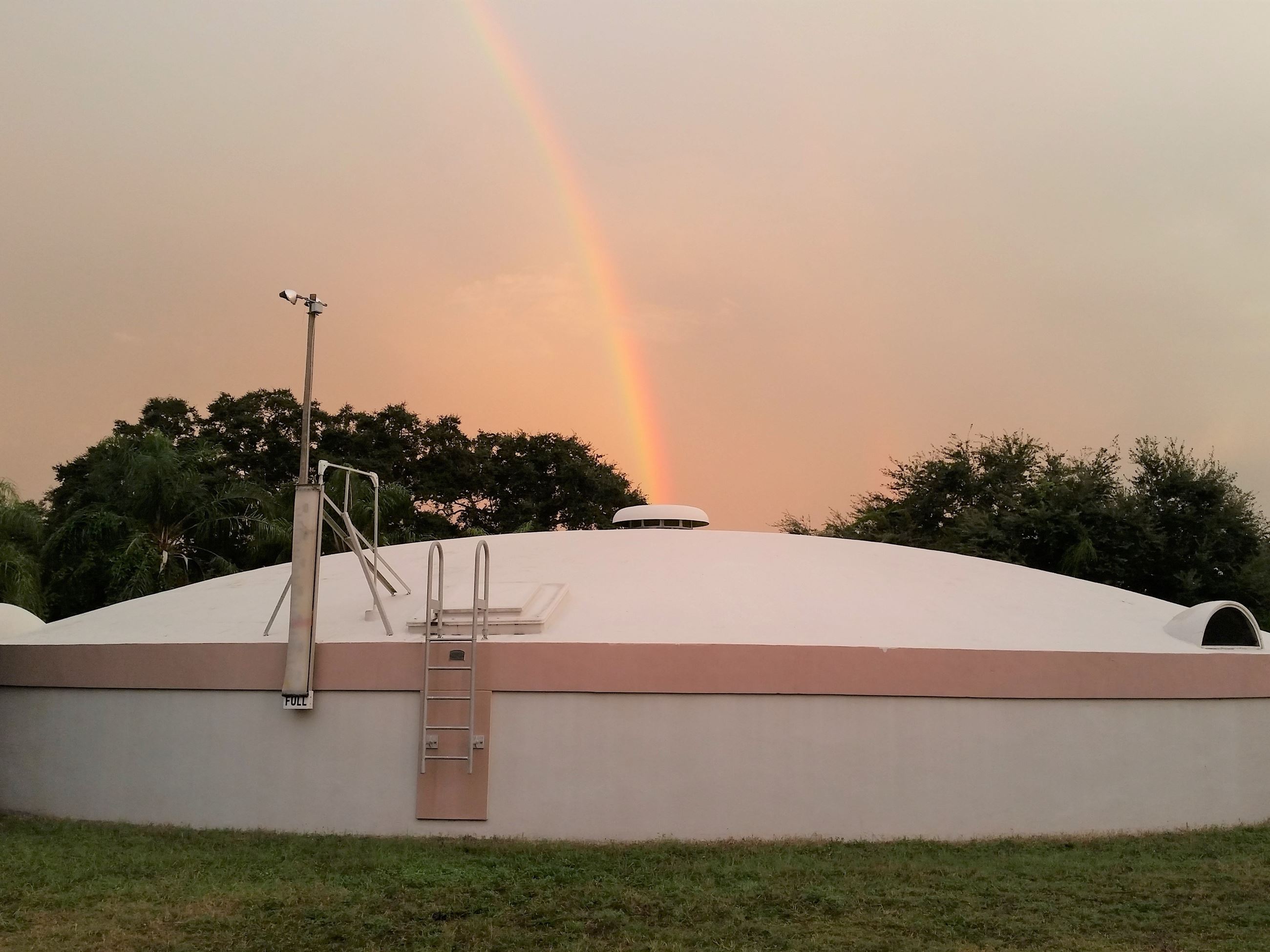 Exterior view of the low, oval-shaped structure that holds treated water prior to distribution.