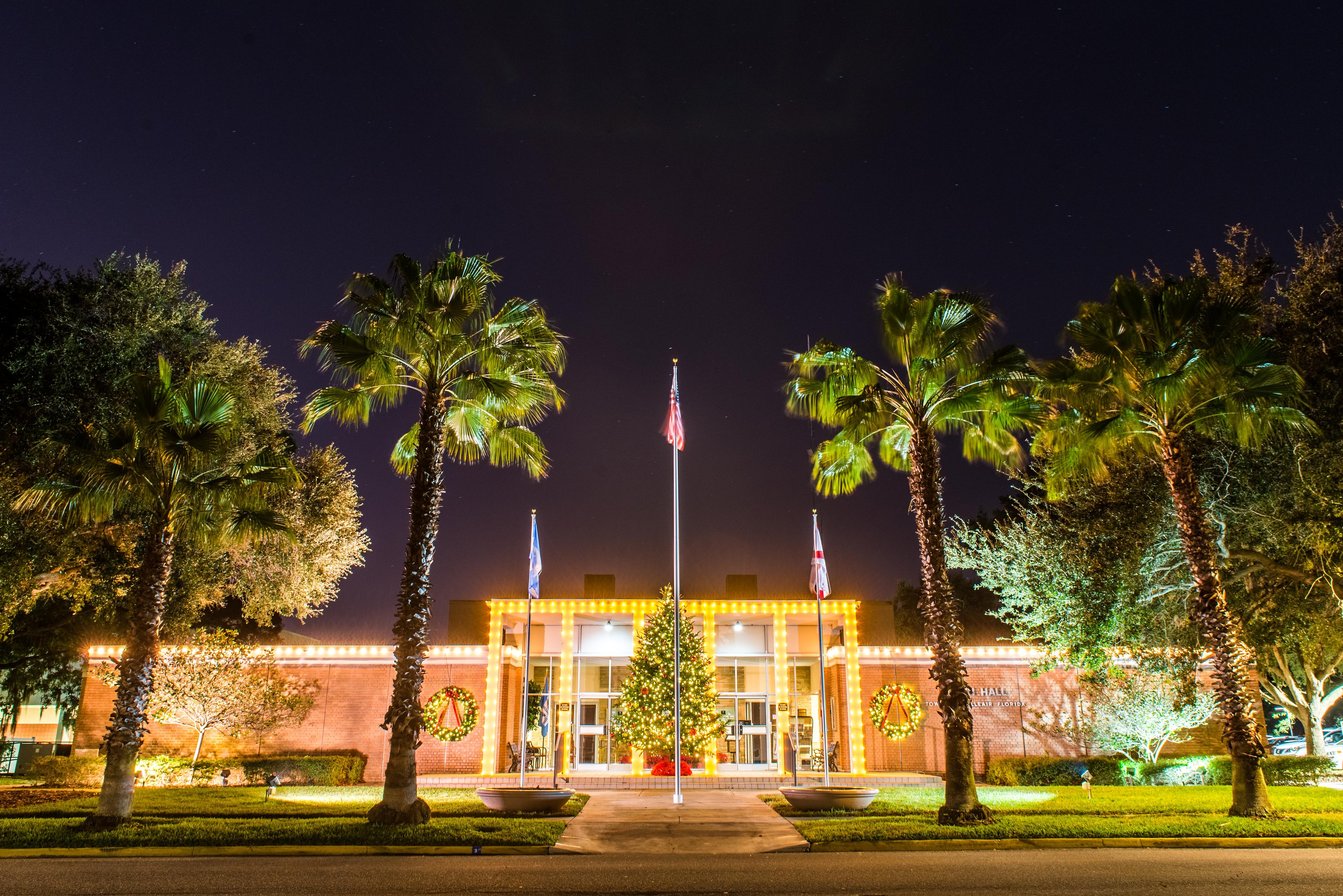 Belleair's Town Hall building light up with holiday lighting from a view across the street