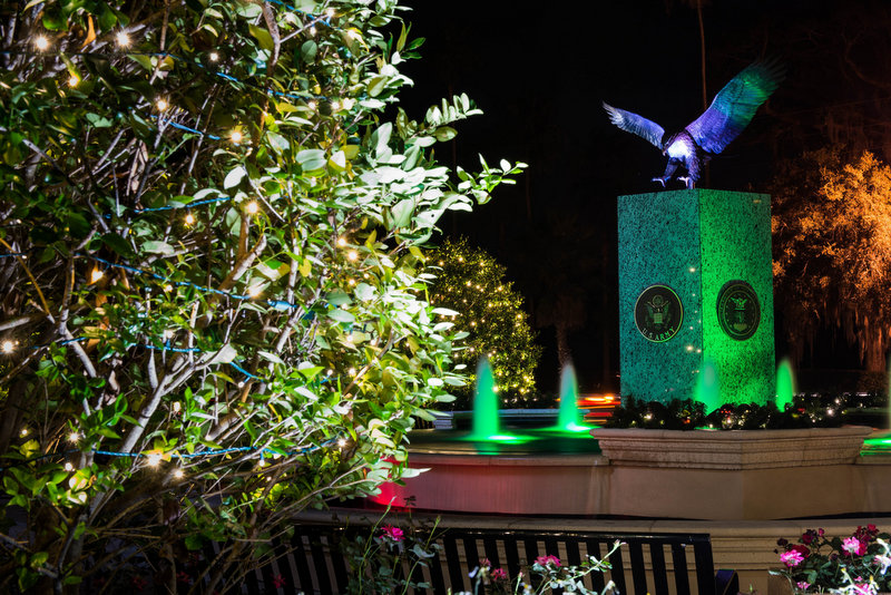 The fountain with an eagle on top at Hunter Memorial Park, lit up with holiday colors