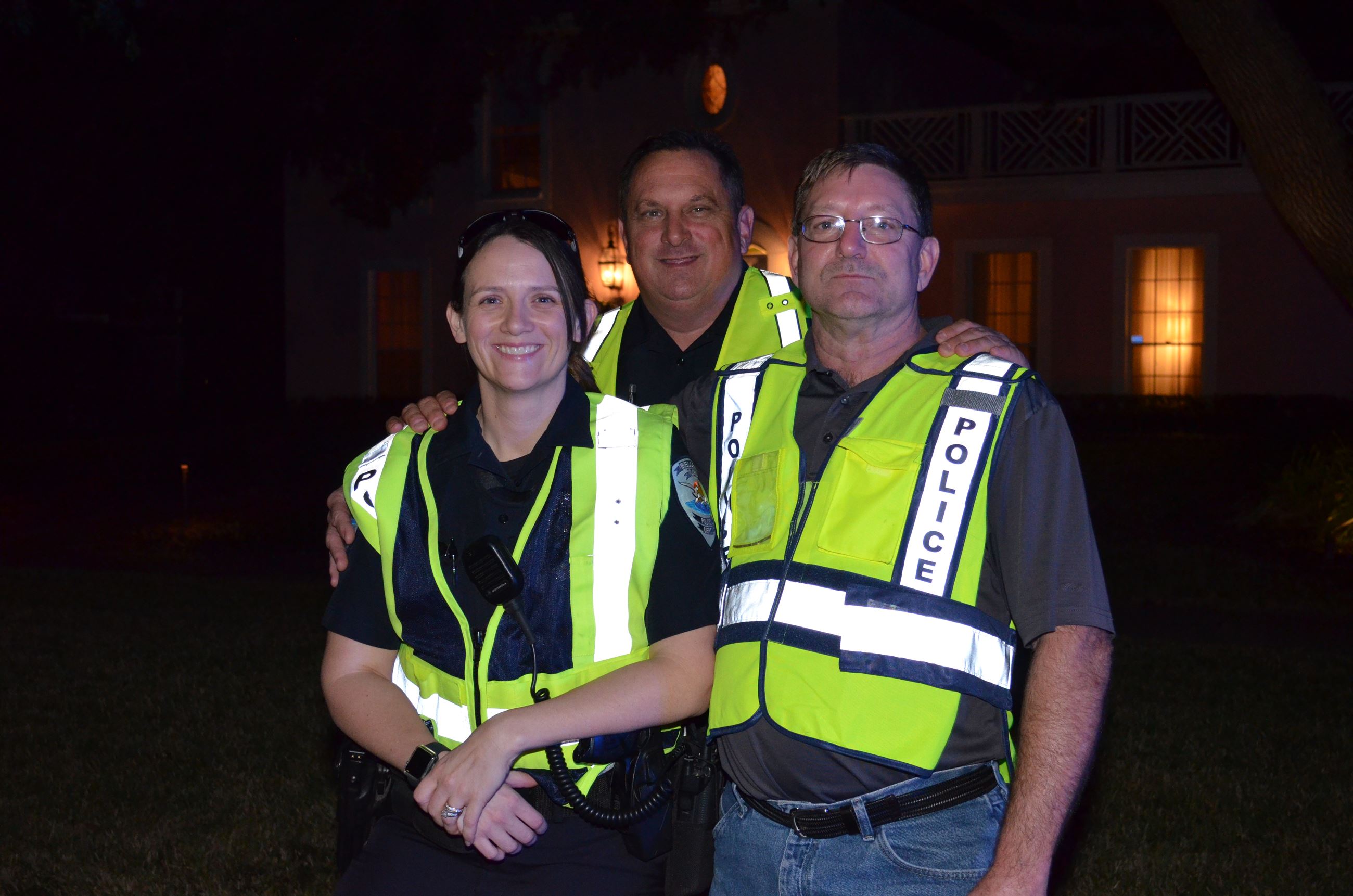 Three Belleair officers pose for a quick photo at night during an event.